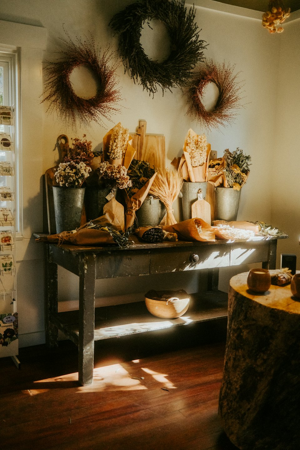 Dried flower bouquets and wooden boards sit on a rustic table.